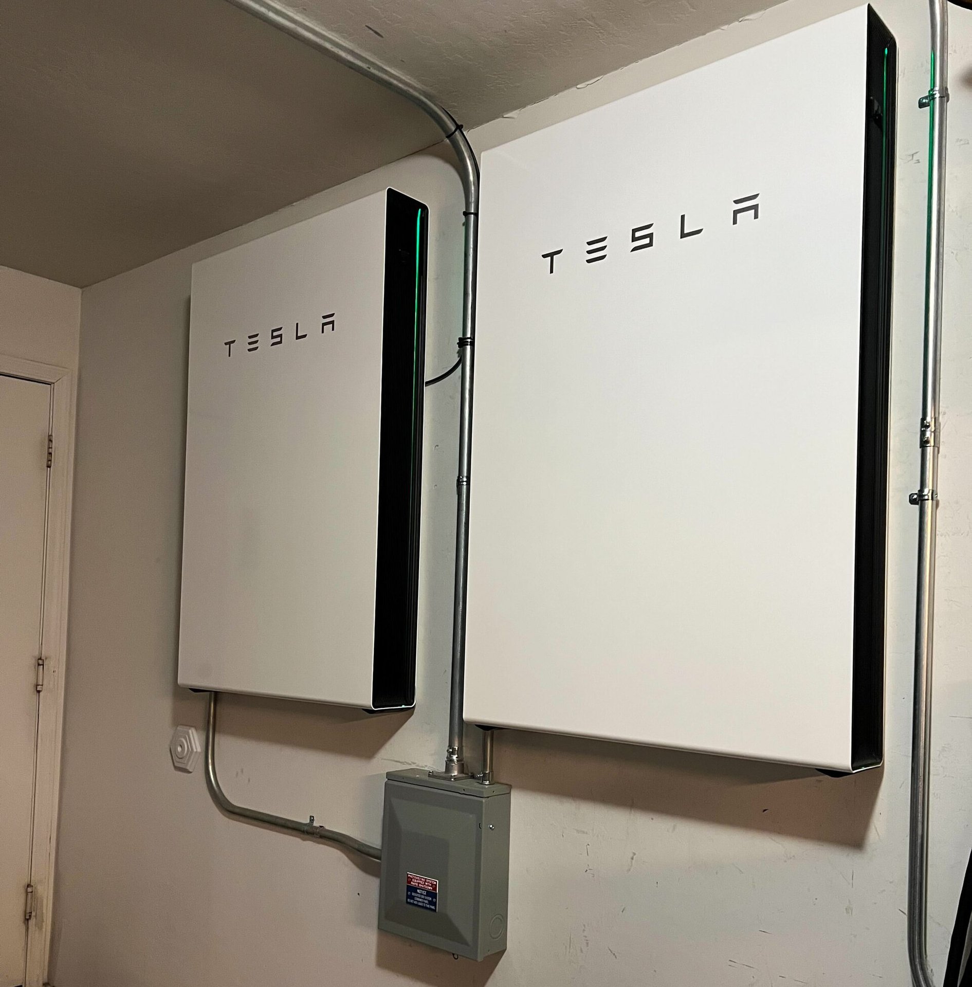 Tesla Powerwall home batteries installed on a garage wall